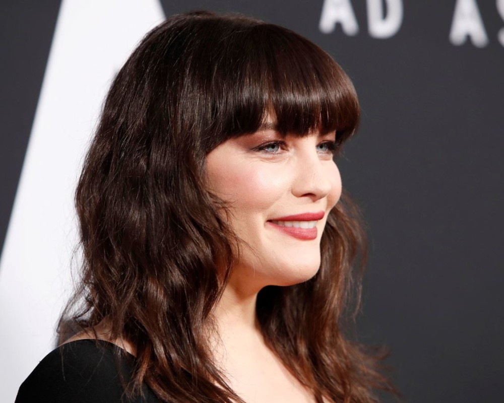 Liv Tyler on the red carpet, sporting blunt-cut bangs.