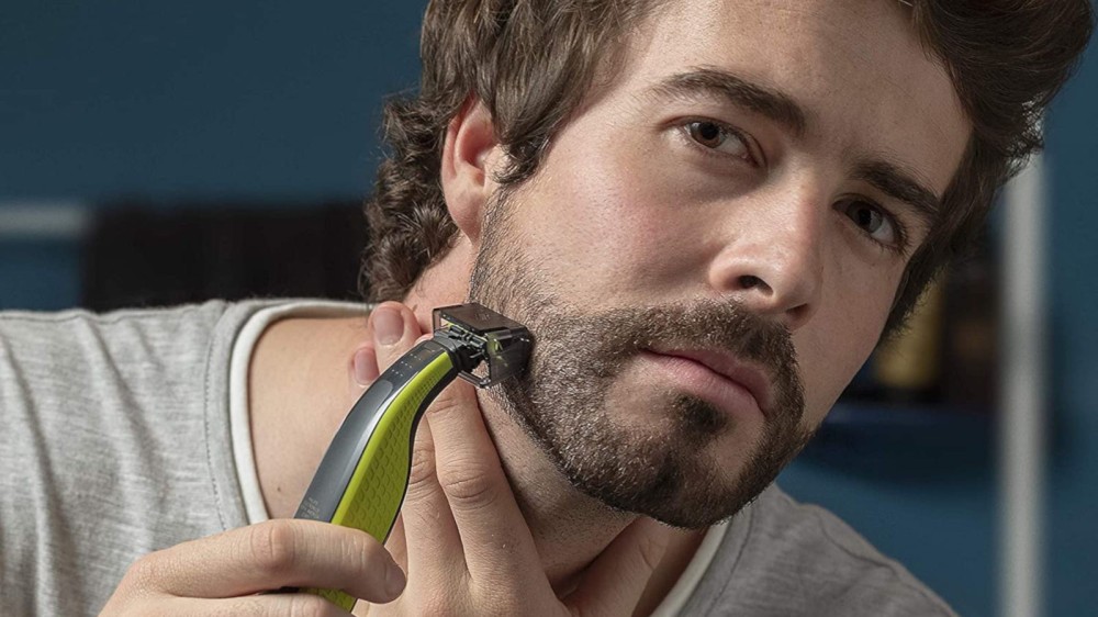 Man trimming short beard with compact handheld beard trimmer