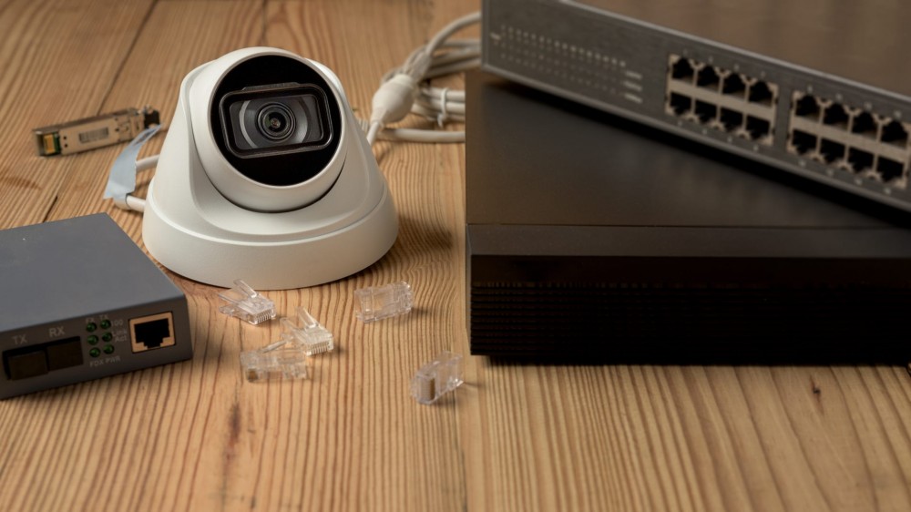 a security camera next to a PoE switch.