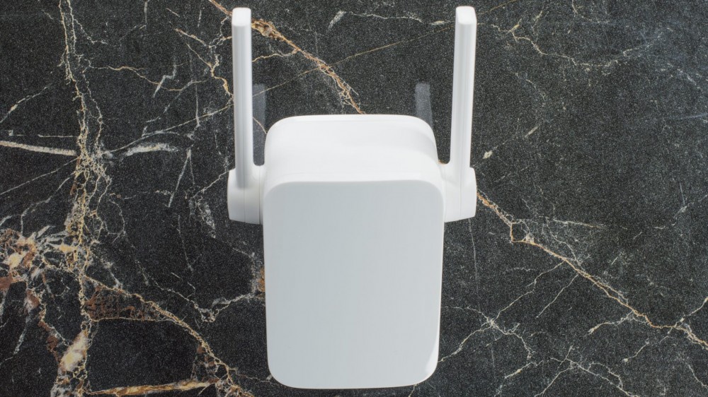 A Wi-Fi range extender on a marble countertop.