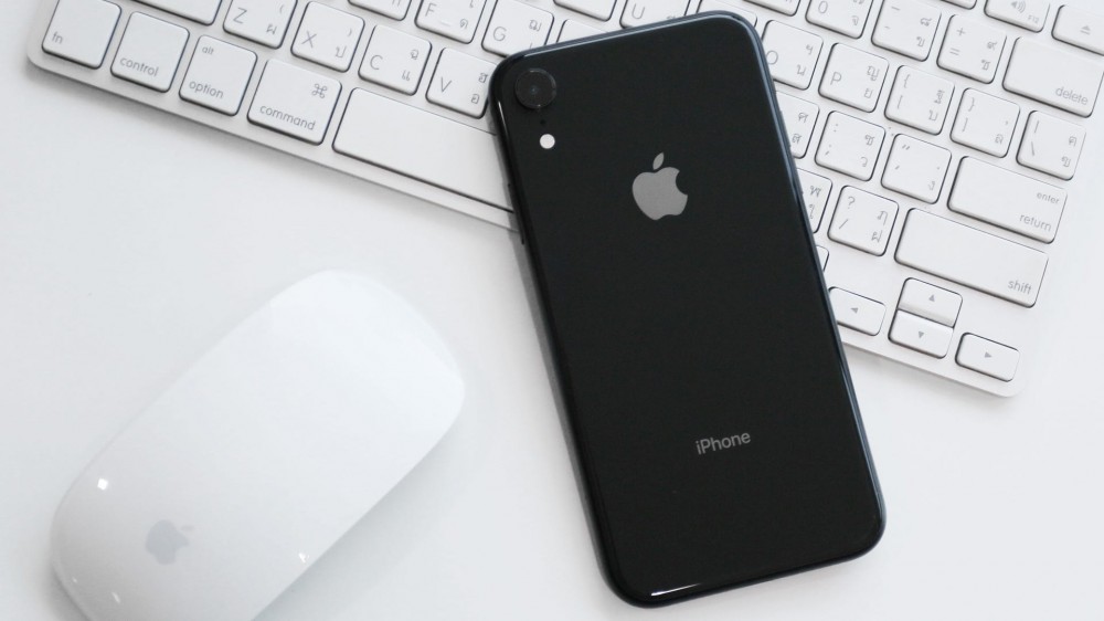 iPhone XR on a table with a Magic Mouse and Magic Keyboard