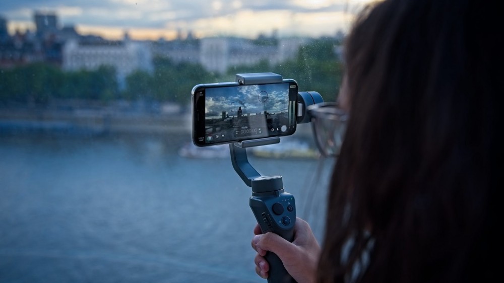 Girl using a phone gimbal to record video.