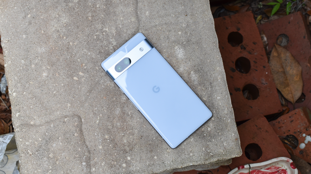 The Google Pixel 7a sitting on a stone slab.