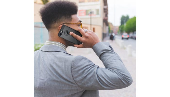 A man looking off into the distance while talking on his iPhone. 